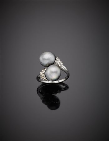 Anello contrariè in oro bianco ornato da due perle grigie di mm. 9,70 circa...